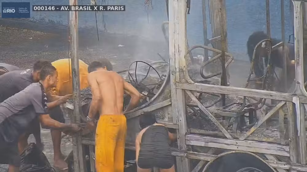 Grupo depena carcaça de ônibus incendiado na Avenida Brasil enquanto veículo ainda soltava fumaça